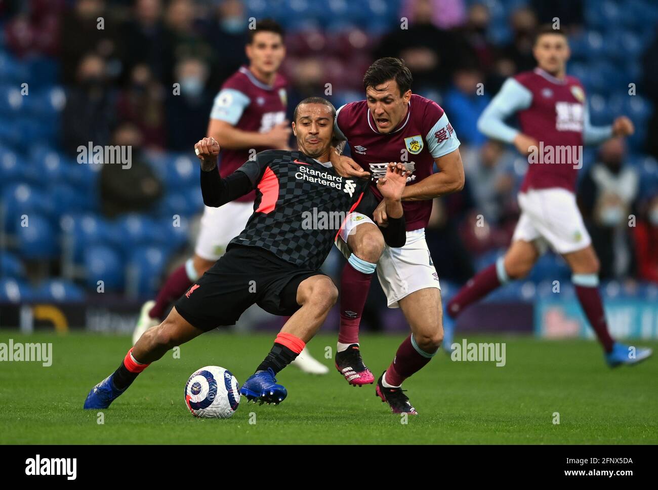 Liverpool's Thiago Alcantara (left) and Burnley's Jack Cork (right) battle for the ball during the Premier League match at Turf Moor, Burnley. Picture date: Wednesday May 19, 2021. Stock Photo