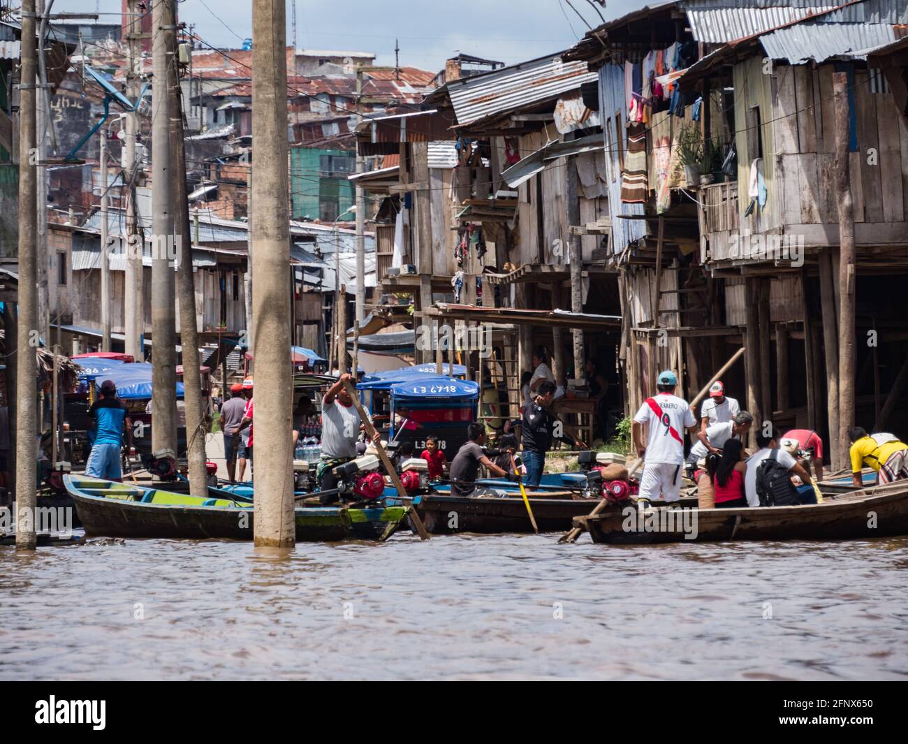 Belen, Peru- Dec 2019: People on the boats between floating houses in the floodplain of the Itaya River, poorest part of Iquitos - Belén. Venice of La Stock Photo