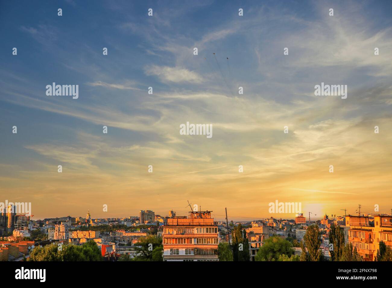 Cityscape with military fighters in the dramatic sunset sky in Kyiv, Ukraine Stock Photo