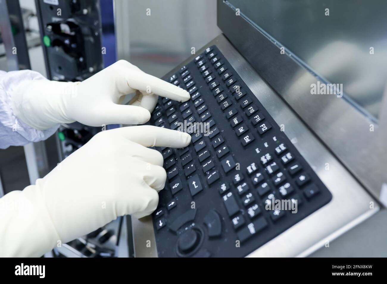 Hands with surgical gloves typing on computer keyboard, Performing computers in medicine concept. Stock Photo