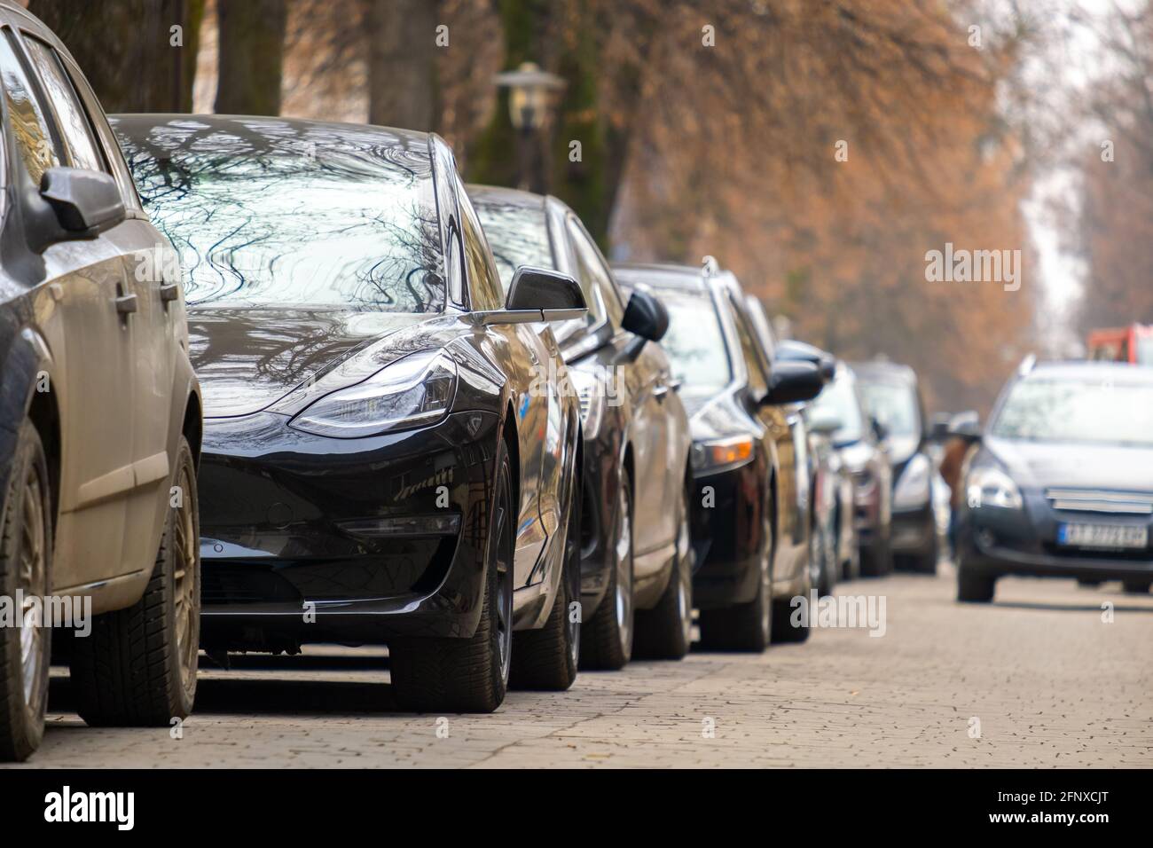 Cars parked in a row on a city street side Stock Photo - Alamy