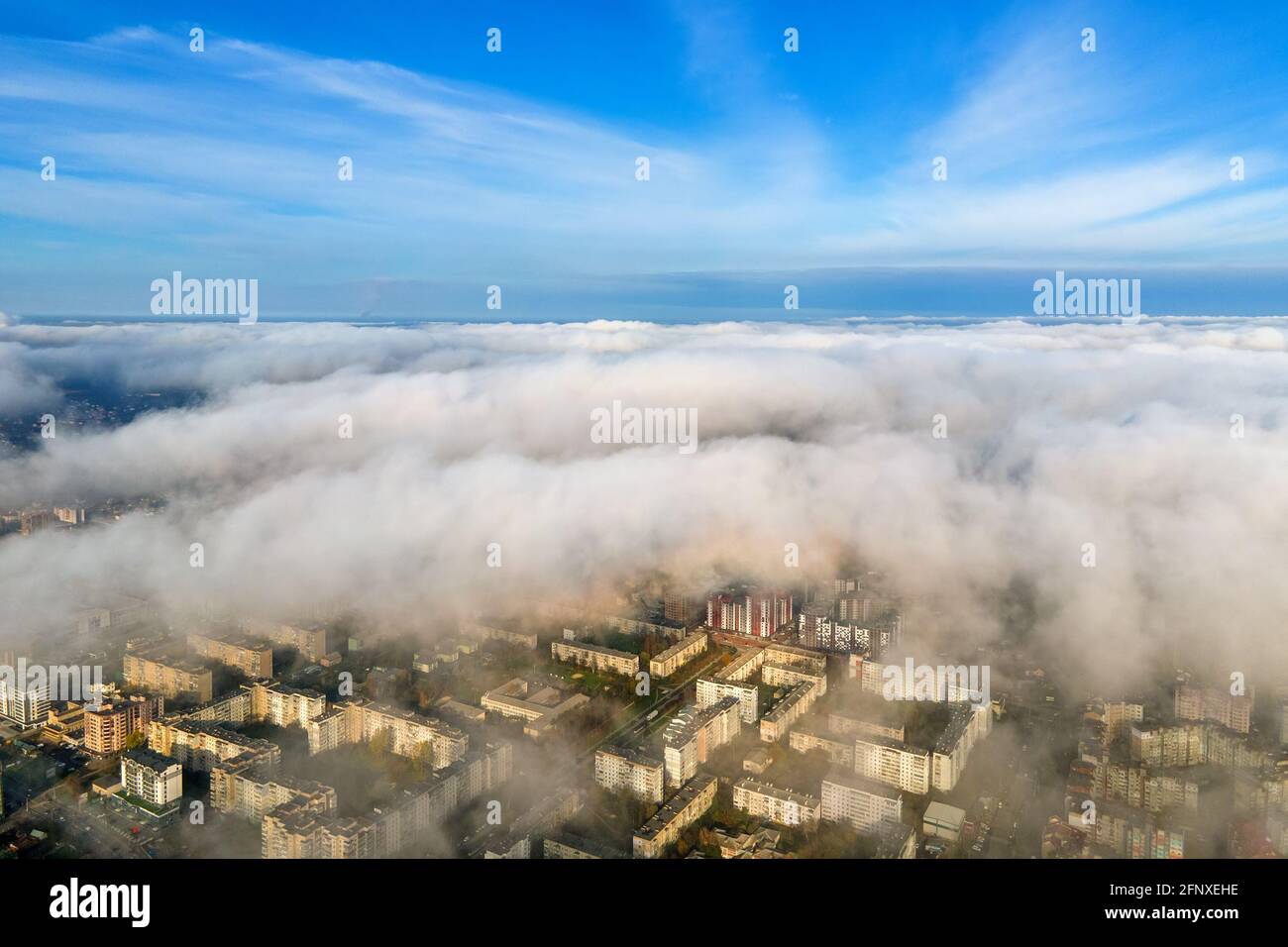 Top aerial view of fluffy white clouds over modern city with high rise ...