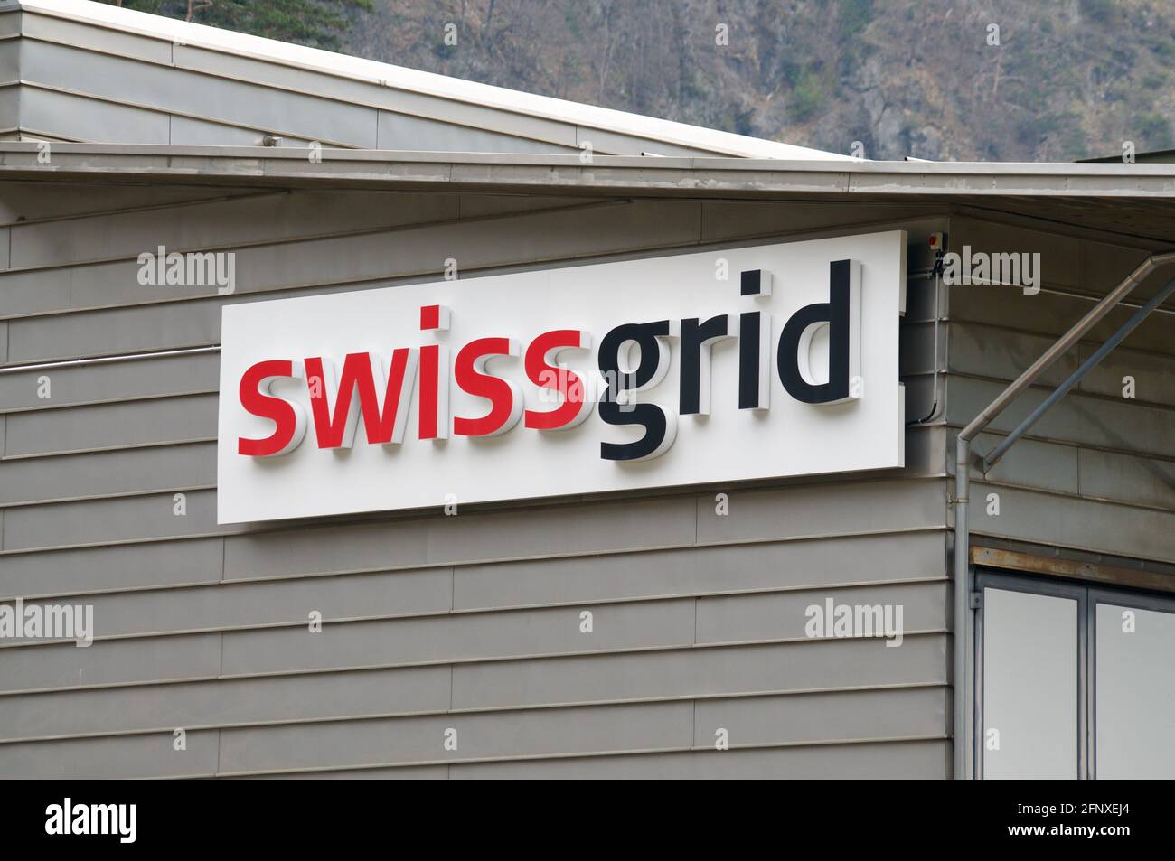 Amsteg, Uri, Switzerland - 18th April 2021 : View of the Swissgrid company sign hanging on a building in Amsteg. Swissgrid is the Swiss grid transmiss Stock Photo