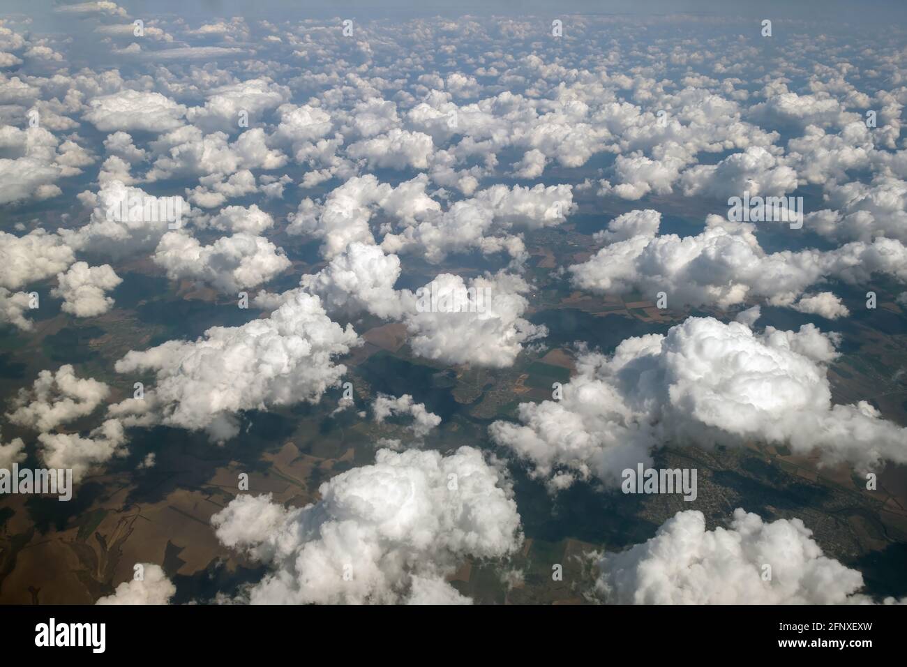 Aerial view from airplane window of white puffy clouds on bright sunny ...