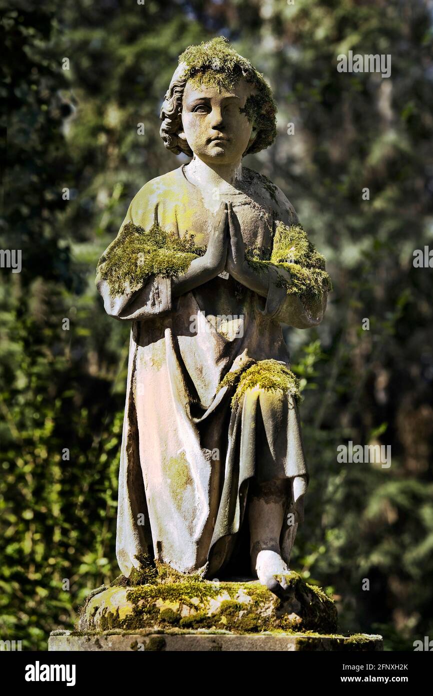 mossy praying burial sculpture on the Melaten cemetery, Germany, North Rhine-Westphalia, Cologne Stock Photo