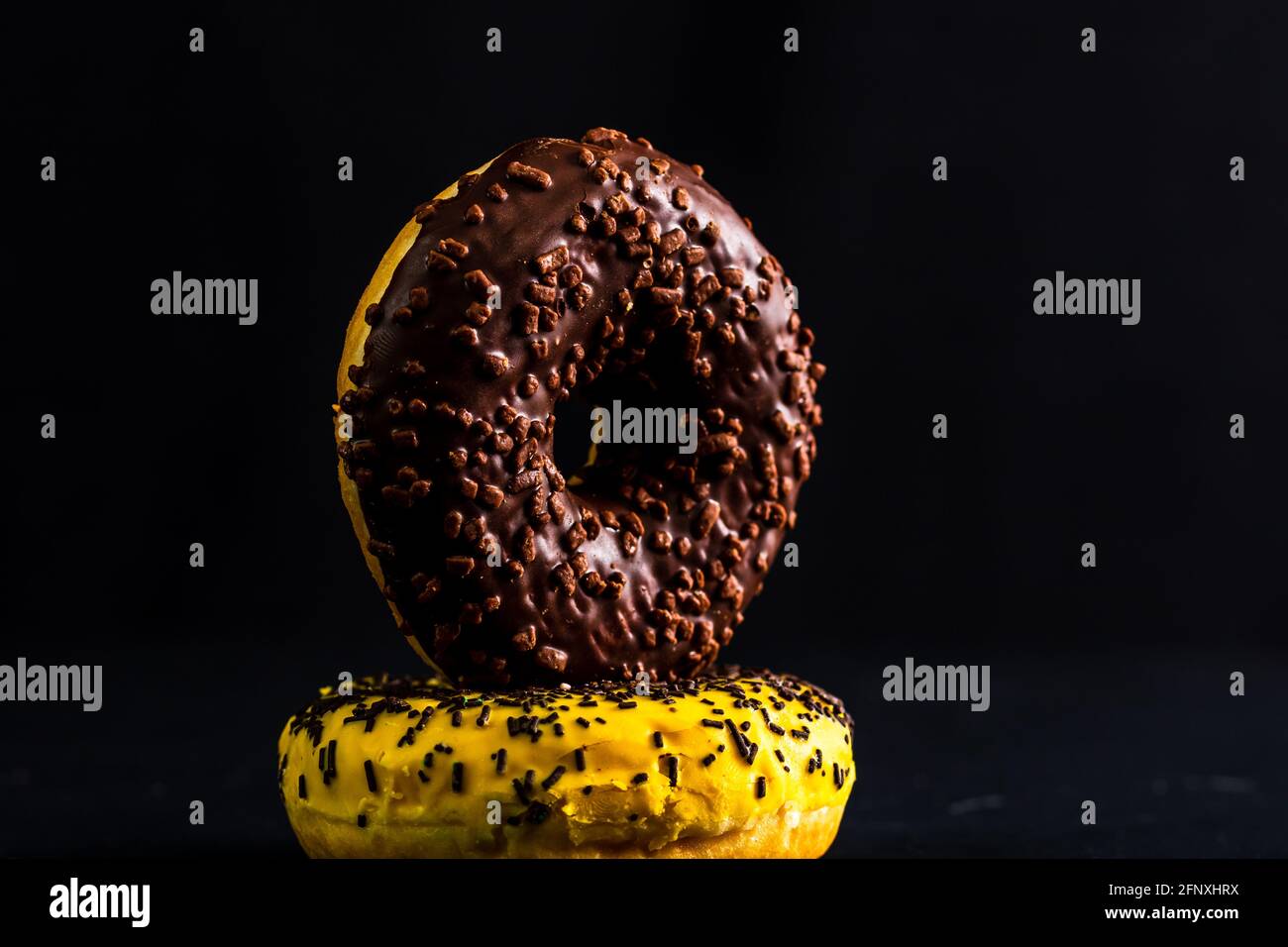 Close up shot of colorful donuts isolated on black background Stock ...
