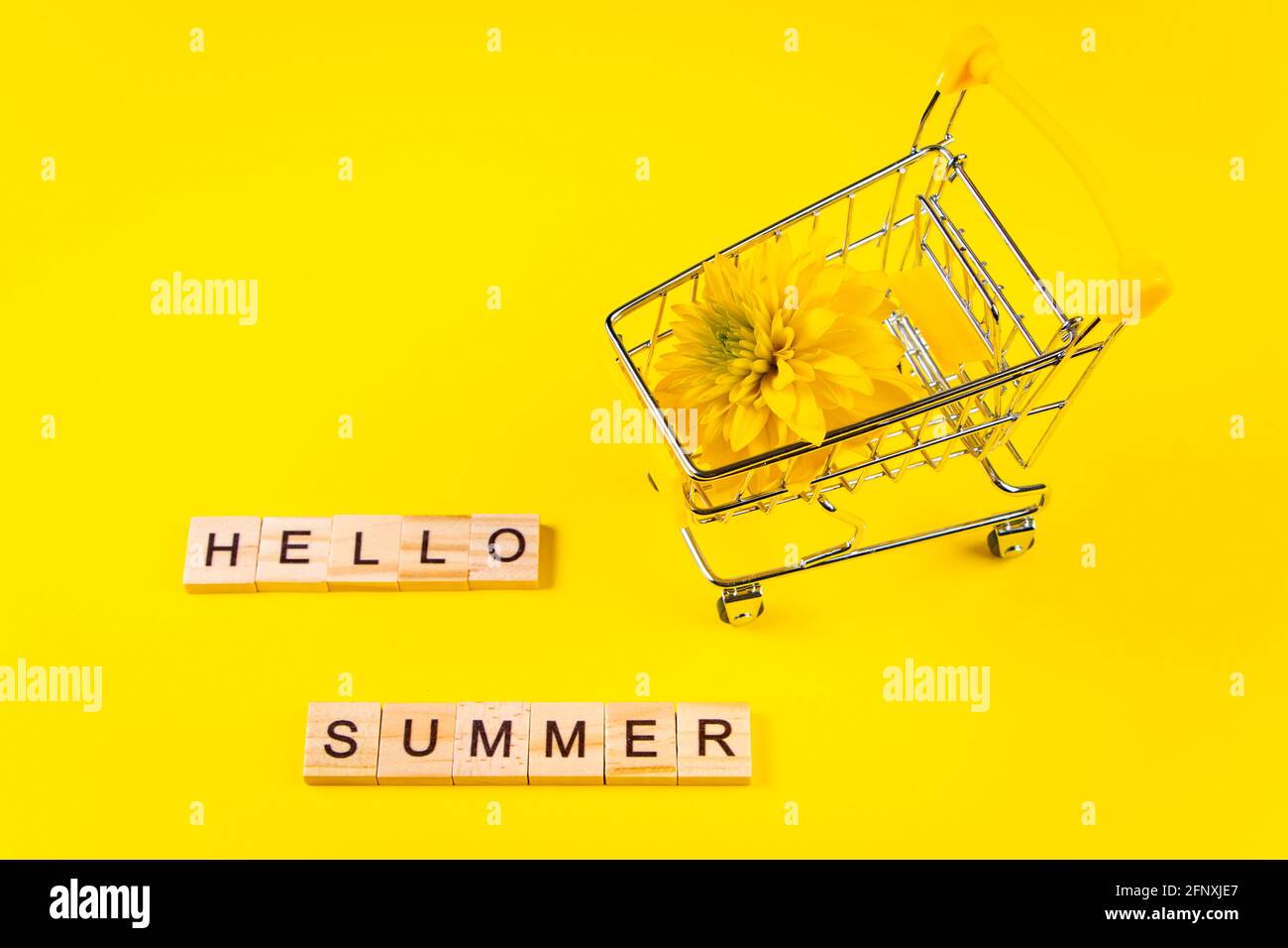 Hello summer. Colorful flowers on a yellow background. Vacation and seasonal shopping concept. Stock Photo