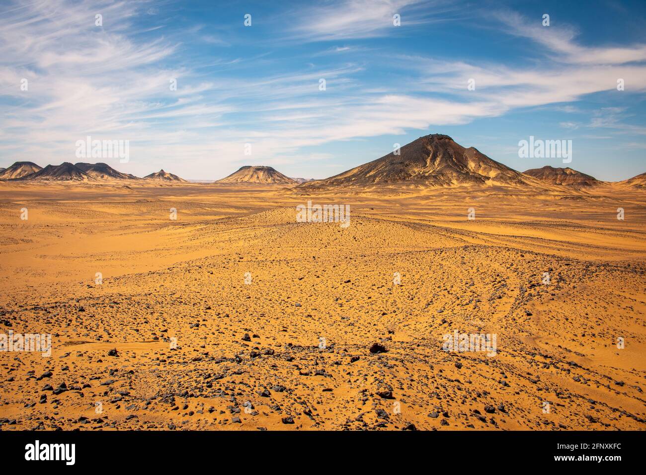 Interesting clouds and blue sky above the Black desert, Egypt. Stock Photo