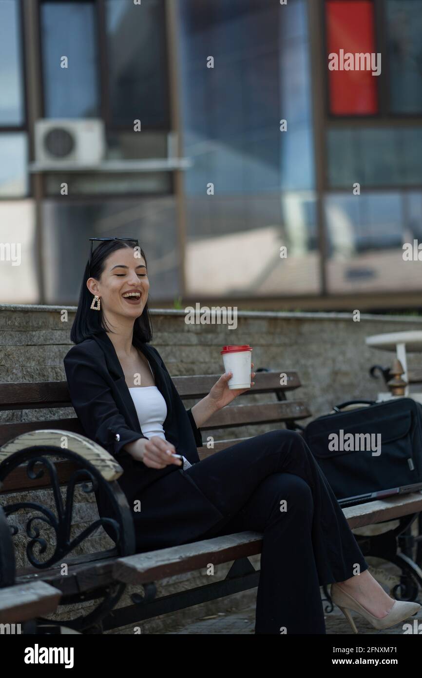 BAttractive businesswoman is laughing while smoking the cigarette Stock  Photo