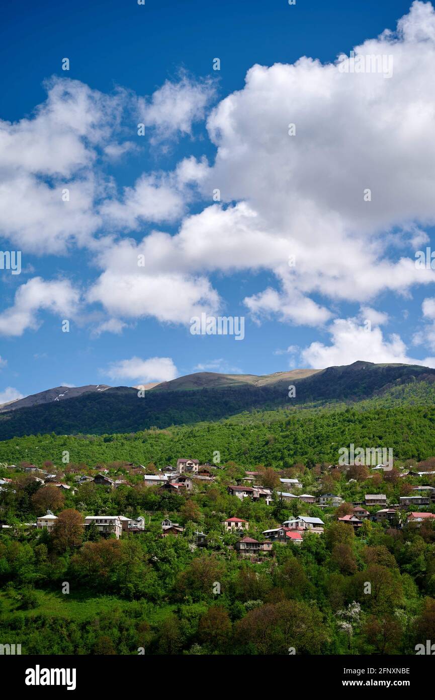 Vertical shot of a village surrounded by hills covered in greenery in Tavush, Armenia Stock Photo
