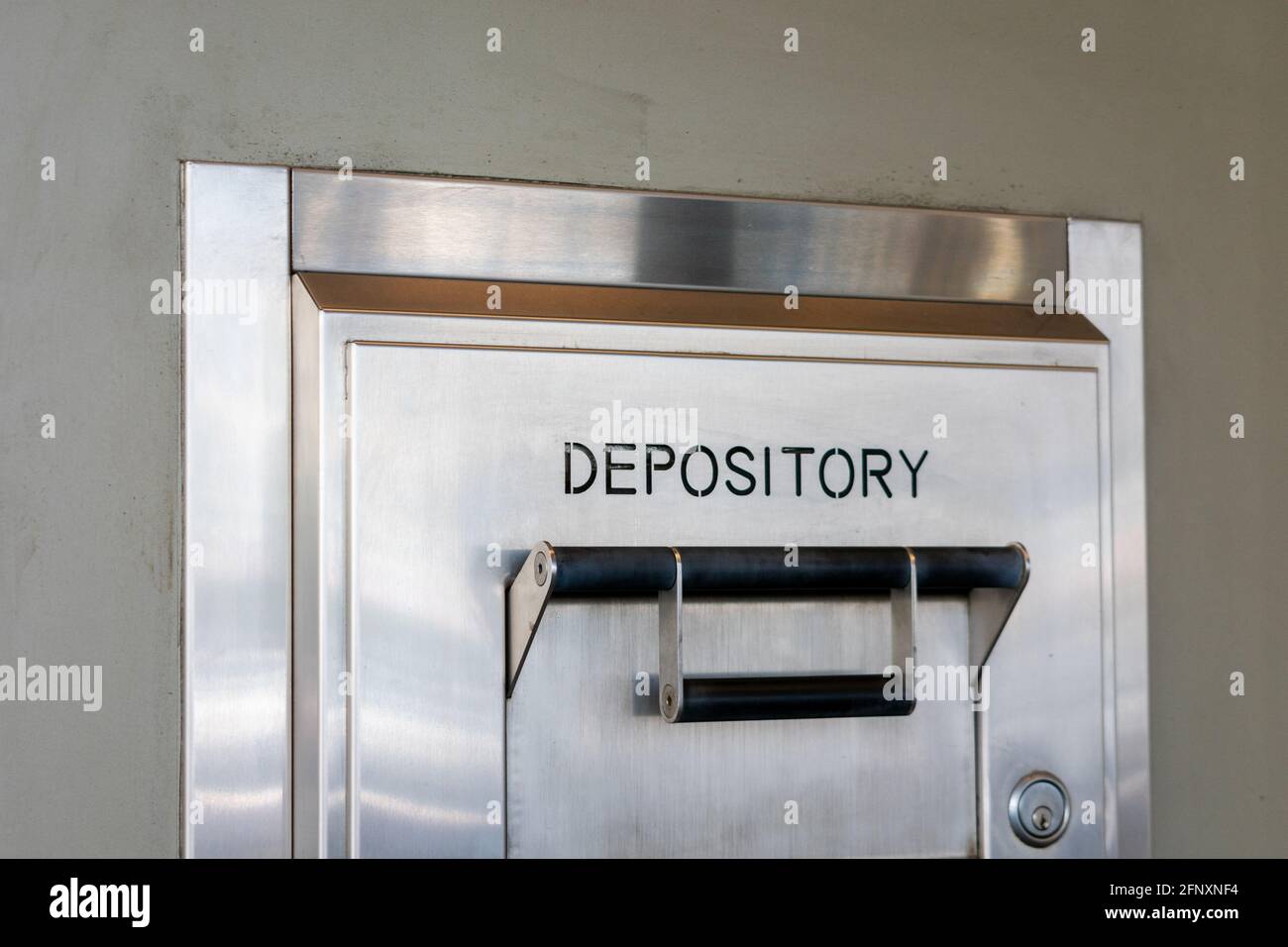 Depository sign on an exterior secured bank drop box attached to the