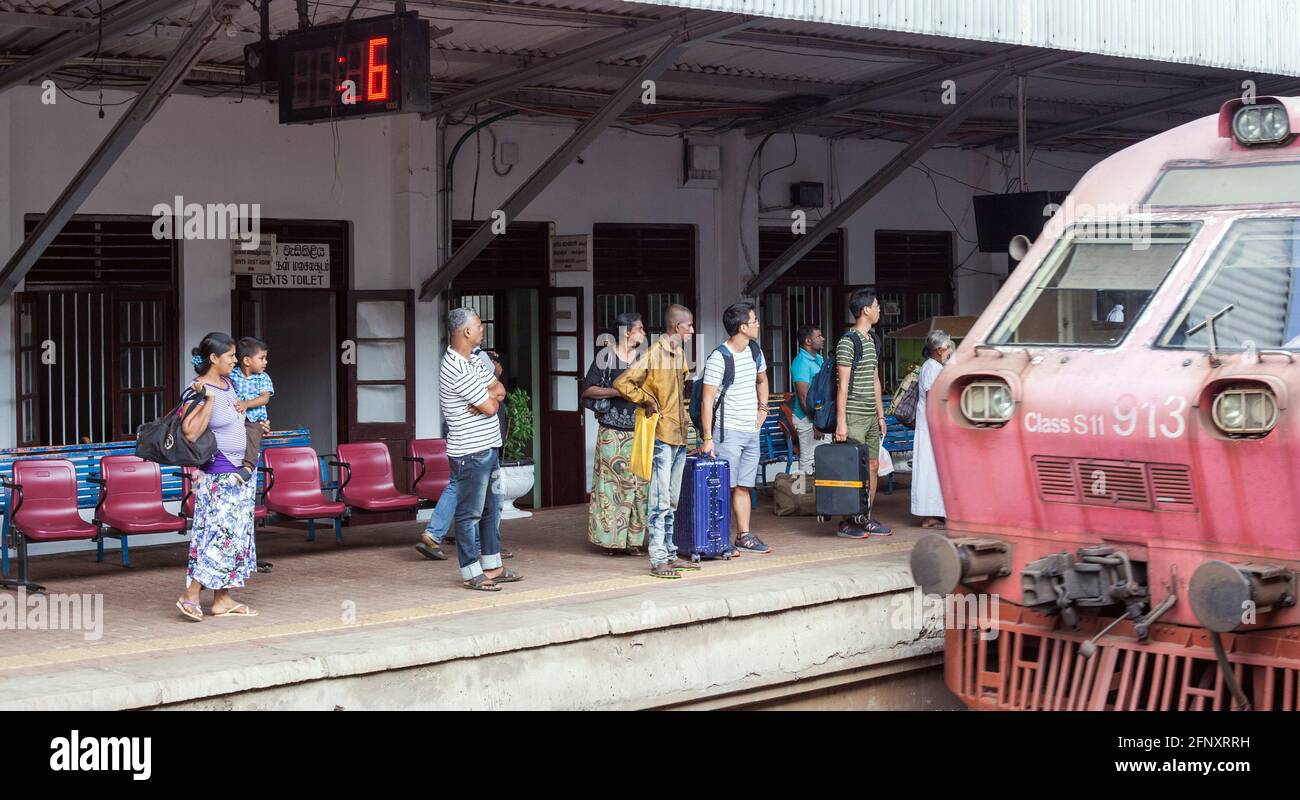 Train passengers waiting on train platform as the Class S11 913 pulls into Anuradhapura railway station, Sri Lanka Stock Photo