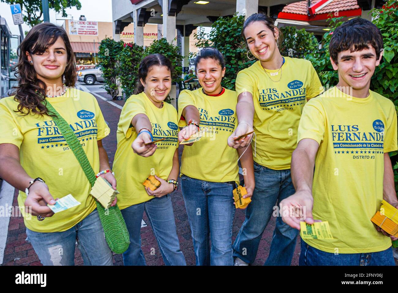 Miami Florida,Little Havana,Calle Ocho,Hispanic teens teenagers volunteers,handing out free campaign material wearing matching tee shirts boys girls Stock Photo