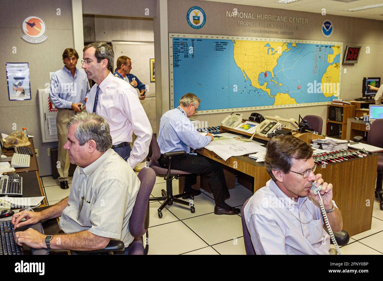 Miami Florida,National Hurricane Center centre,inside interior during Katrina weatherman weathermen meteorologists checking studying weather data Stock Photo