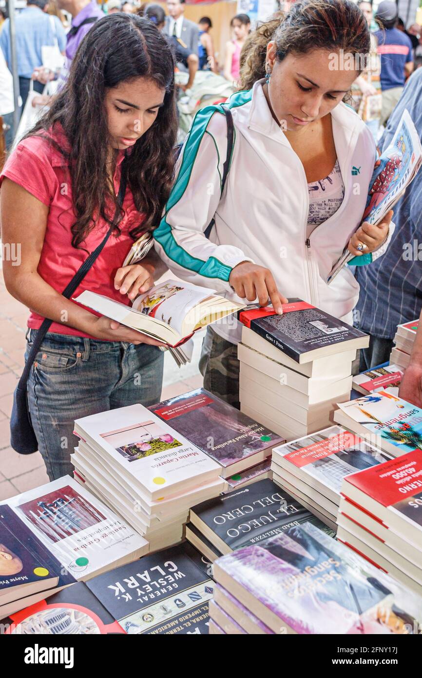 Miami Florida,Dade College campus Miami Book Fair International,vendor vendors seller browsing reading seller stacks books,Hispanic teen teenage teena Stock Photo