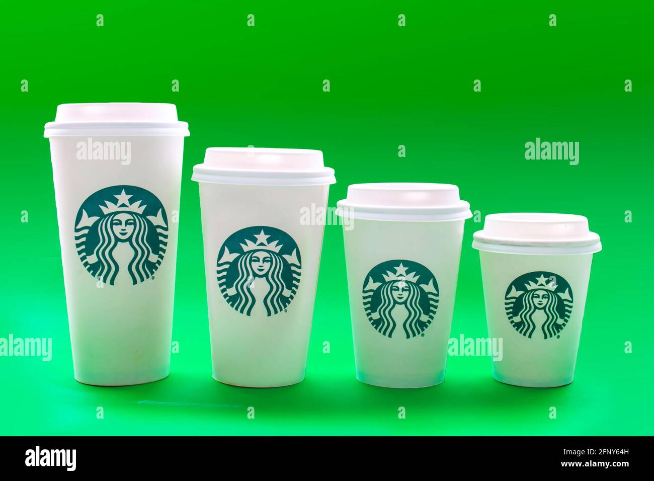 https://c8.alamy.com/comp/2FNY64H/calgary-alberta-canada-may-19-2021-starbucks-coffee-cups-of-different-sizes-on-a-green-background-2FNY64H.jpg