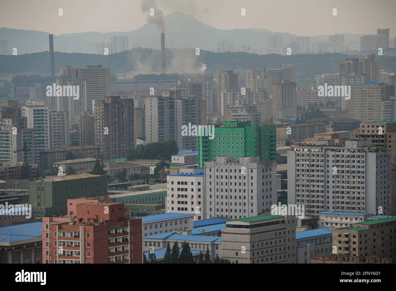 09.08.2012, Pyongyang, North Korea, Asia - Elevated cityscape shows smoking chimneys and a significant air pollution with smog over buildings. Stock Photo