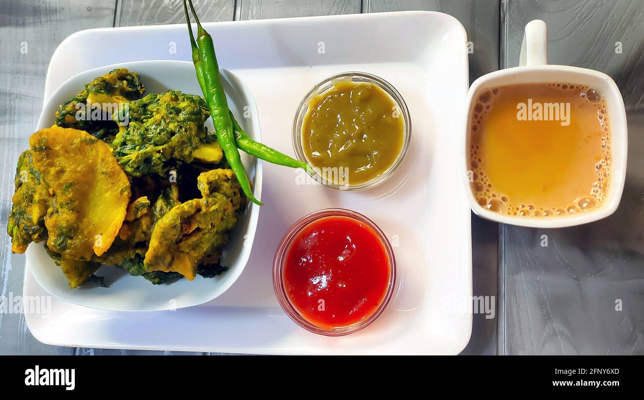 Homemade tasty Palak pakoda or pakora known as Spinach Fritters, served with ketchup. Favourite Tea-time snack from India Stock Photo
