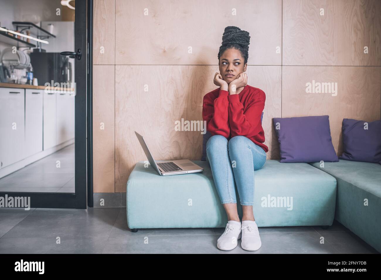 Young african american woman sitting and looking tired Stock Photo