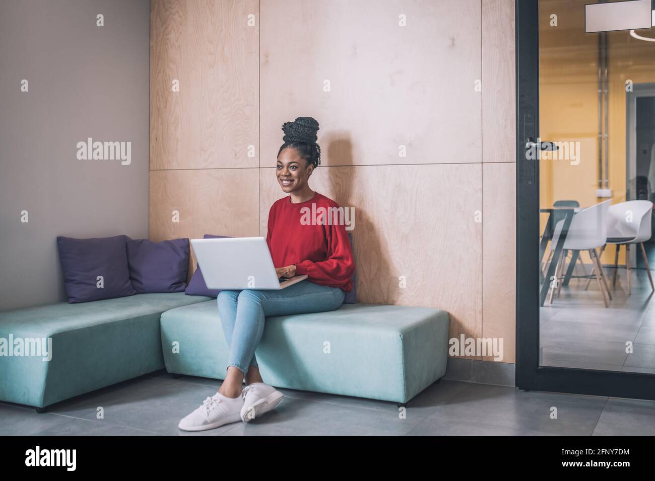 Young black woman sitting and working on a laptop Stock Photo - Alamy
