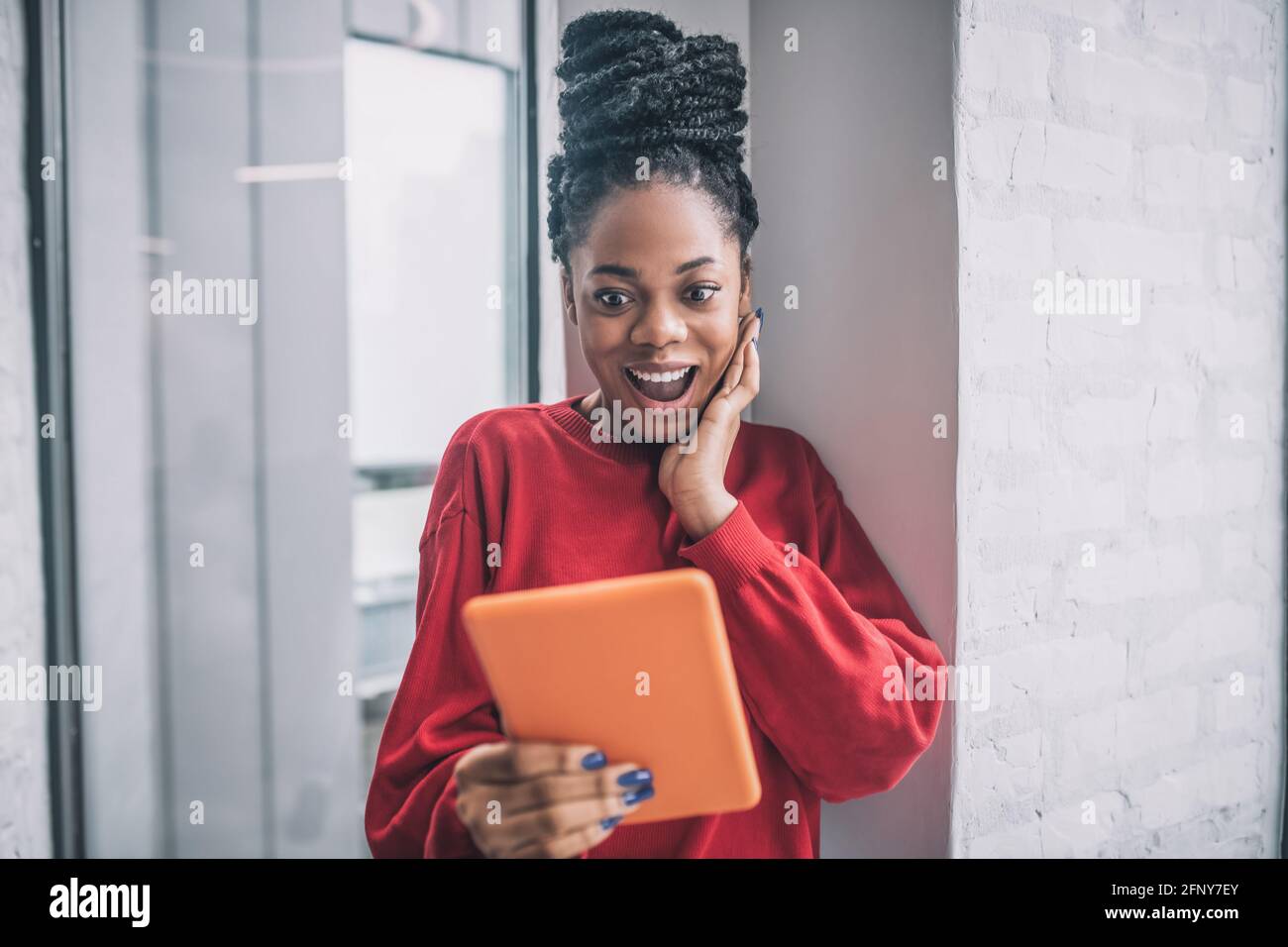 African american cute woman with a tablet looking excited Stock Photo