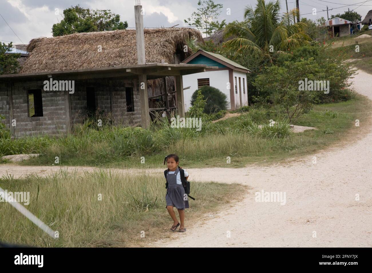 A young girl walking home from school in the Mayan community of San Miguel, Toledo, Belize Stock Photo