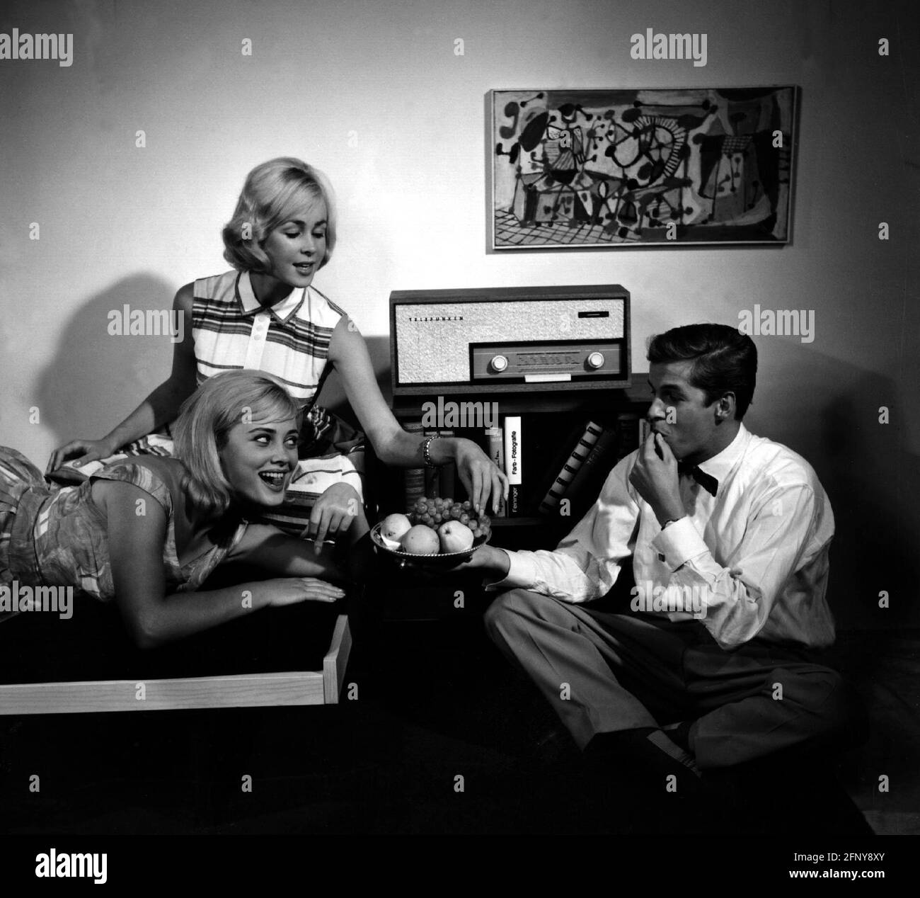 people, teenager, two blonde and one young man eating fruits and listening to Telefunken radio, 1961, ADDITIONAL-RIGHTS-CLEARANCE-INFO-NOT-AVAILABLE Stock Photo
