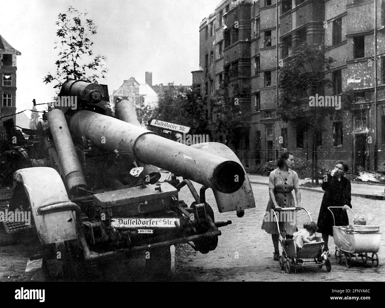 postwar period, cities, Berlin, two women with prams beside a destroyed heavy German howitzer, road sign 'Duesseldorfer Strasse', EDITORIAL-USE-ONLY Stock Photo
