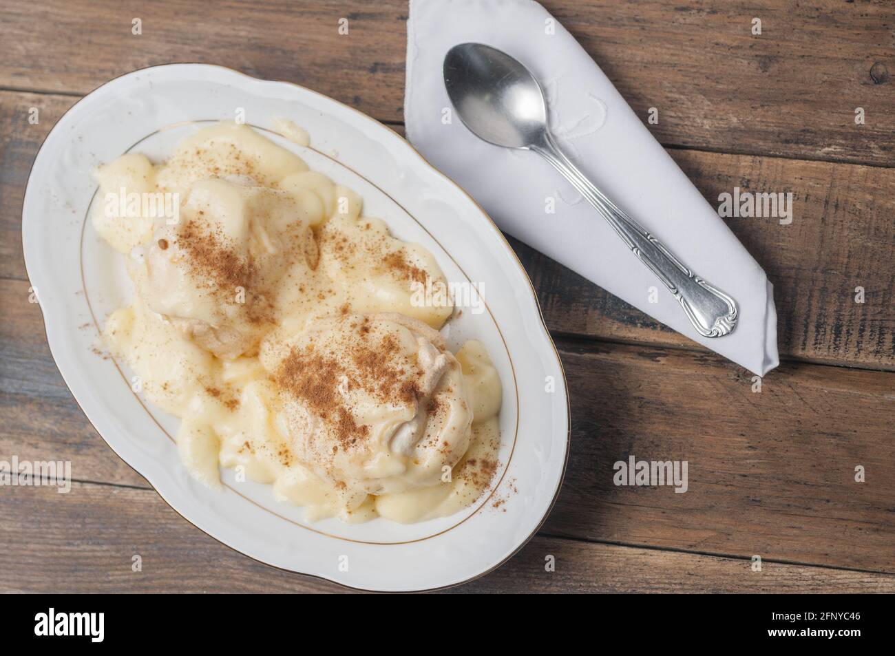 Top view of floating island dessert meringue with custard and cinnamon