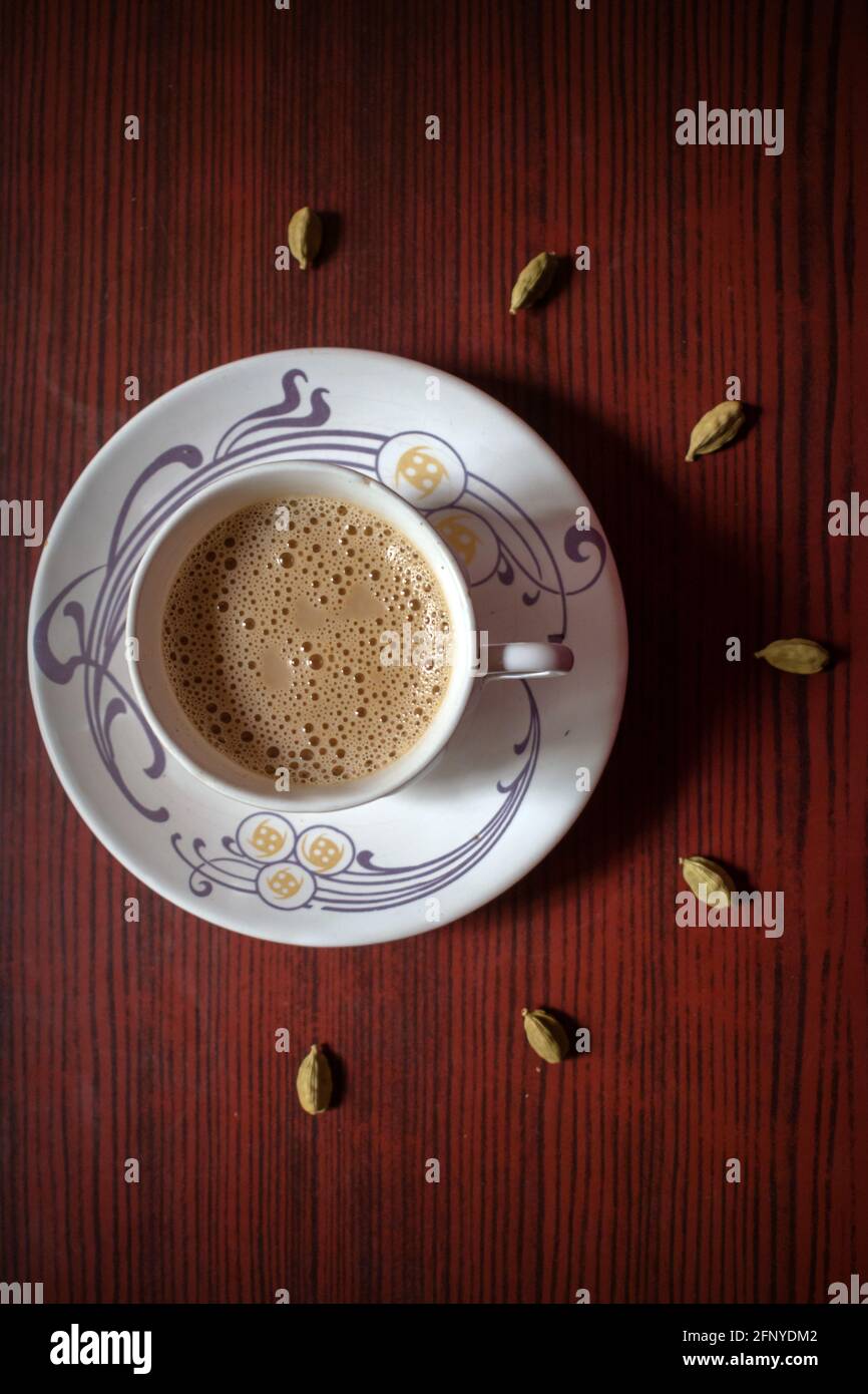 Top view of cup of Indian masala tea with some cardamom on a wood background Stock Photo