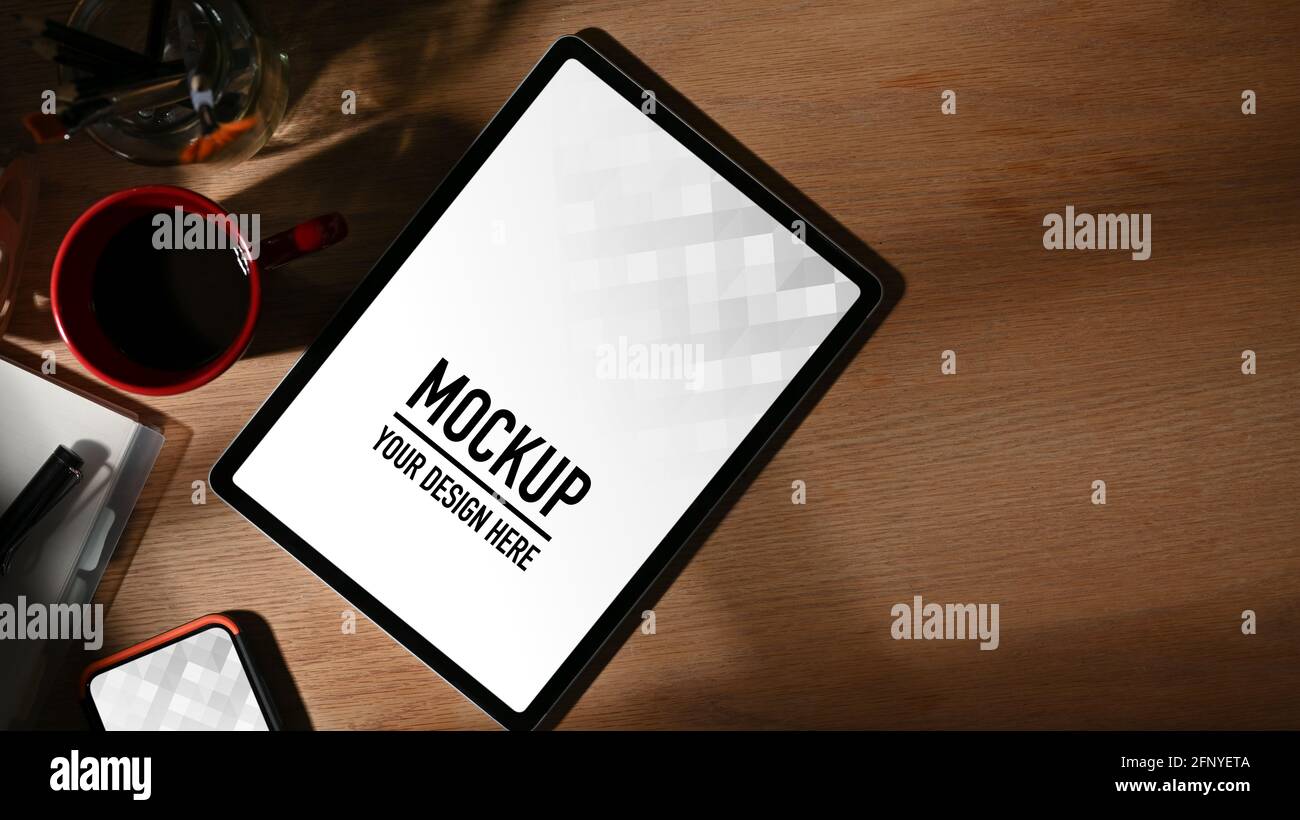 Top view of worktable with tablet, coffee cup, supplies and copy space