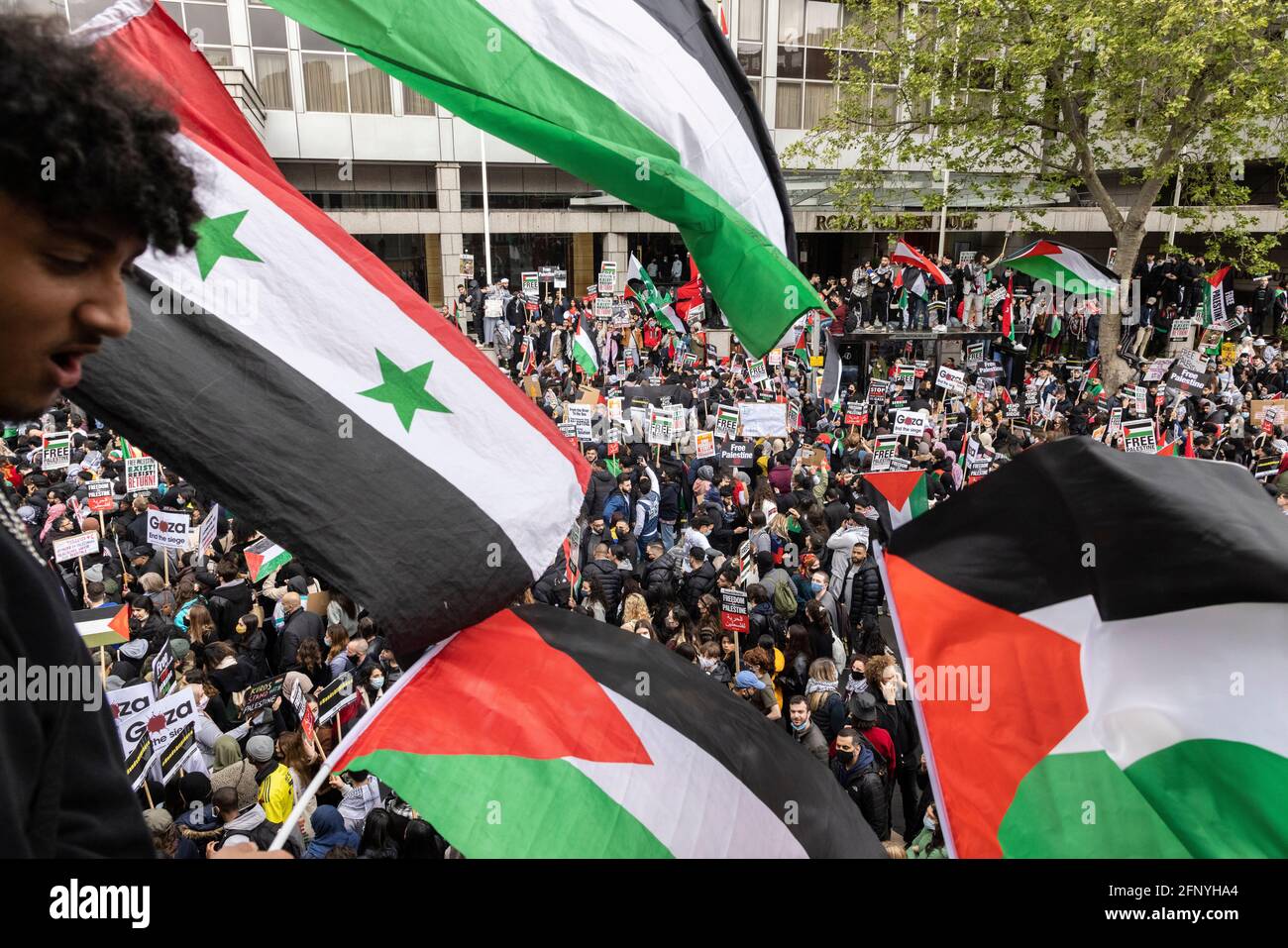 Flags flying above a crowd, 'Free Palestine' solidarity protest, London, 15 May 2021 Stock Photo
