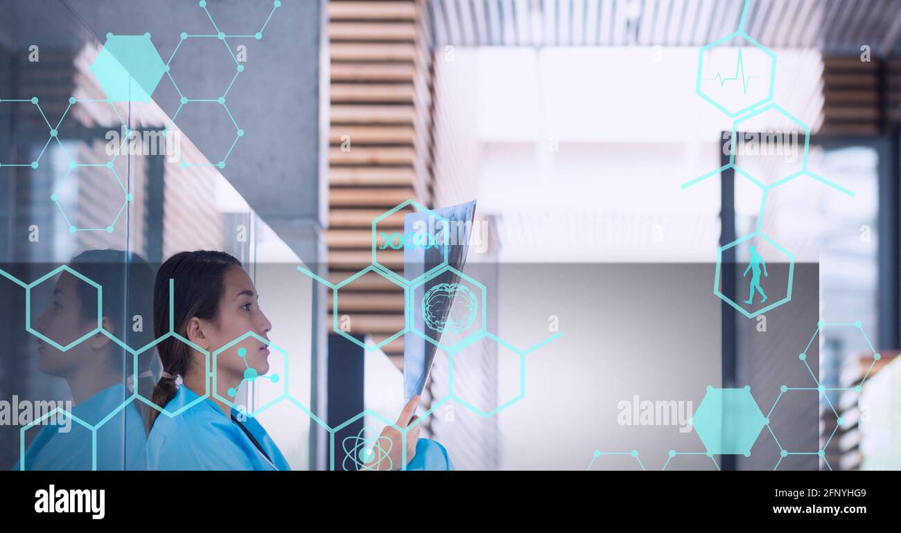 Composition of medical data and icon over female doctor with x ray scan Stock Photo