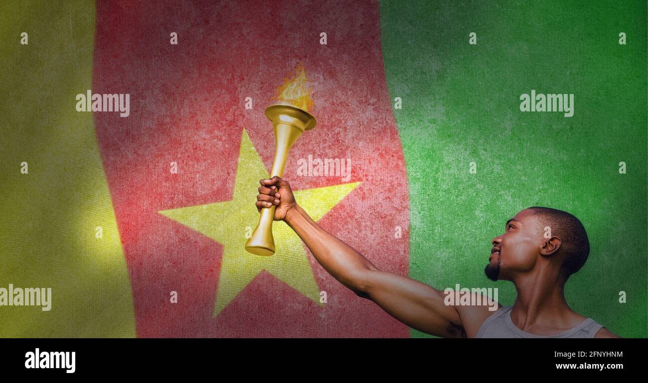 Man holding olympic torch over cameroonian flag, olympic games and sports event concept Stock Photo