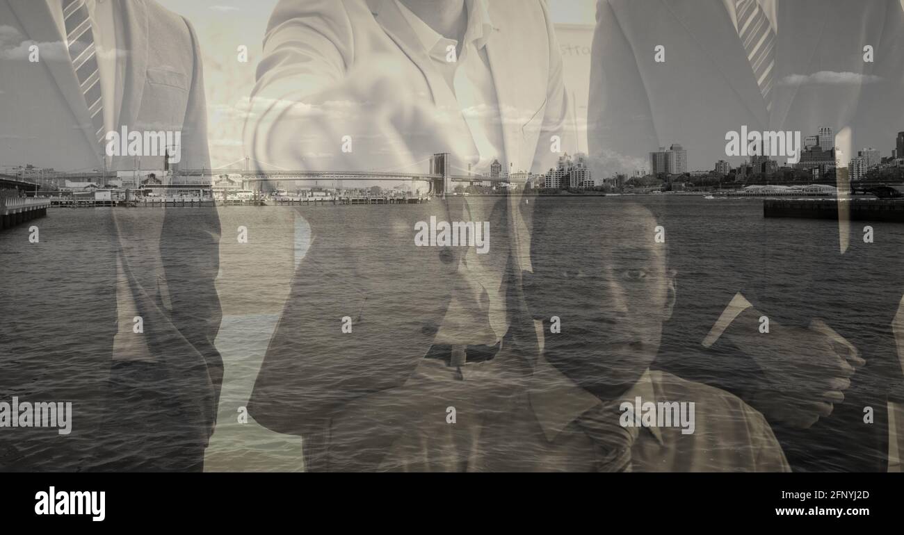 Composition of businessman pointing at camera over cityscape Stock Photo
