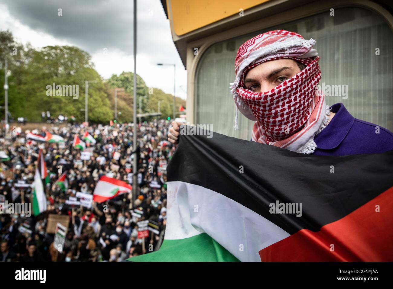 Portrait of protester with flag above crowd, 'Free Palestine' solidarity protest, London, 15 May 2021 Stock Photo