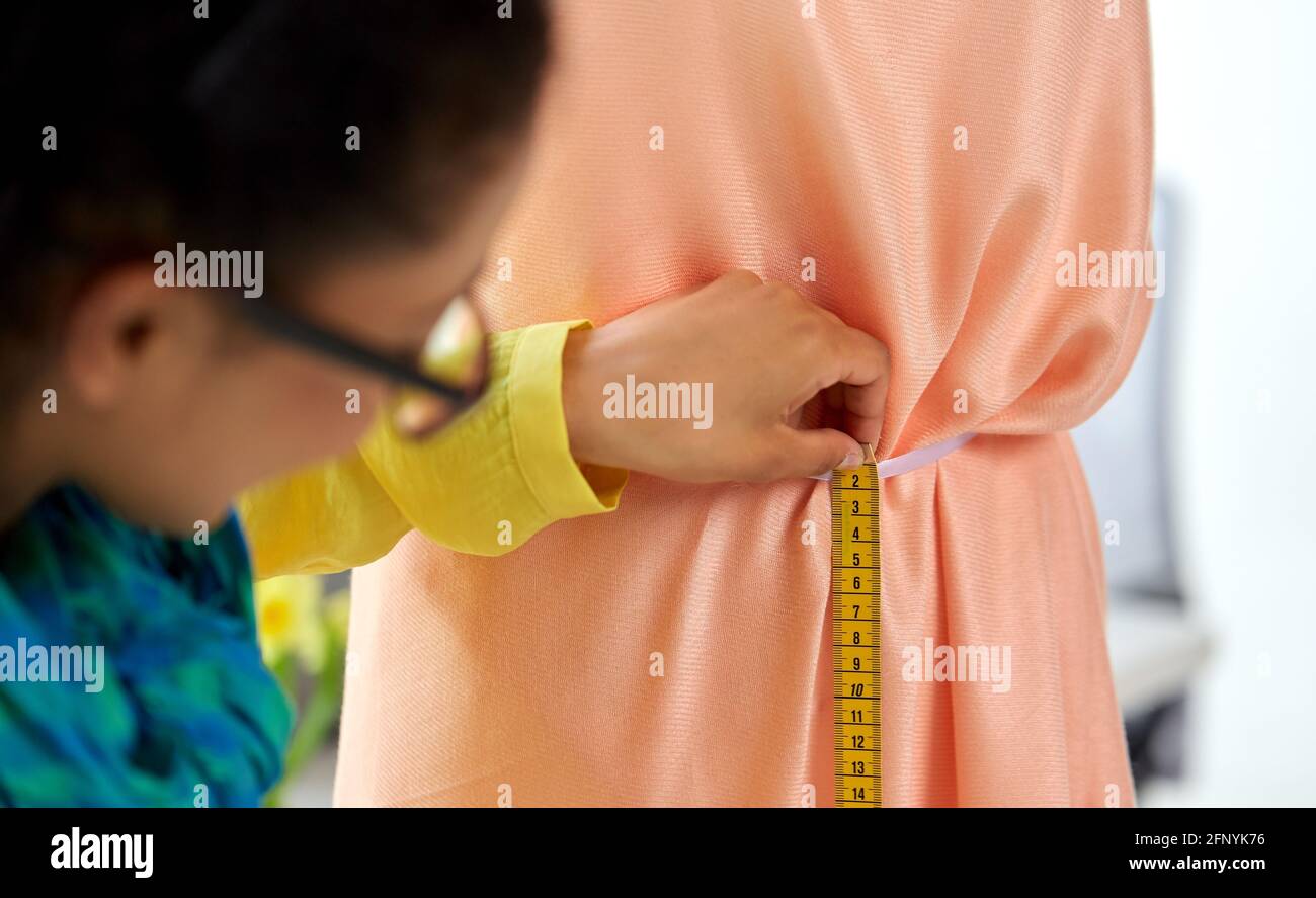 fashion designer measuring dress with tape measure Stock Photo Alamy