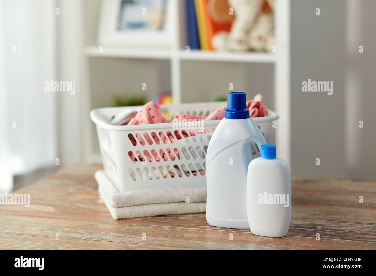 baby clothes in laundry basket with detergent Stock Photo - Alamy