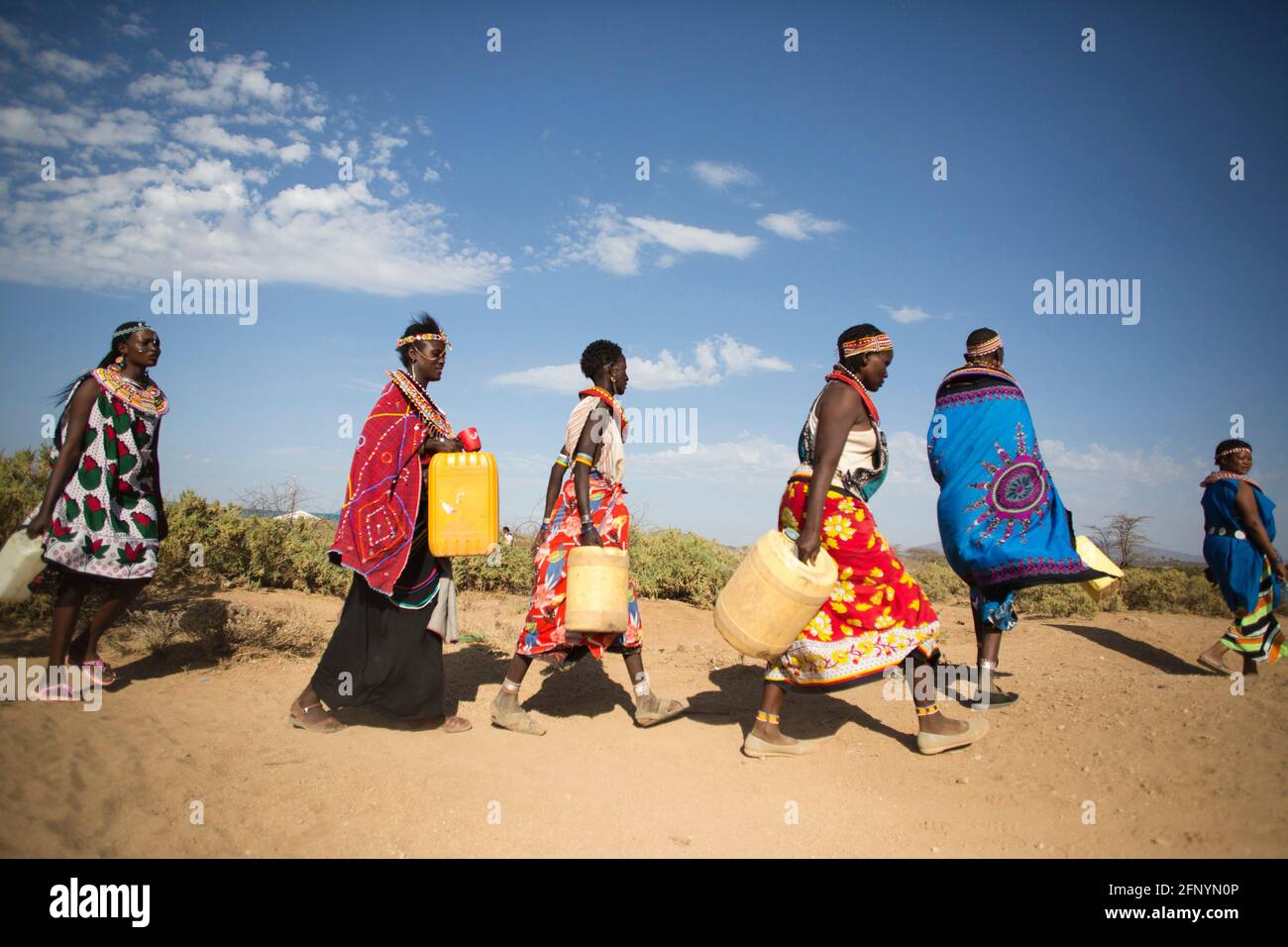 Women walk to collect water to a river near the village of Umoja in Samburu, Kenya on February 19, 2015. Stock Photo