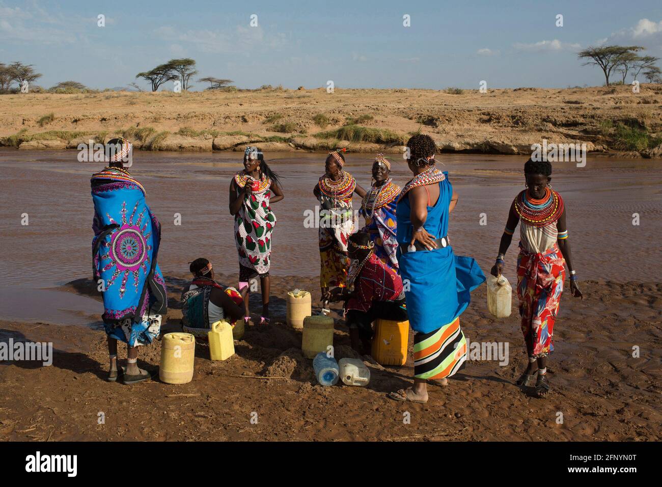 Women collect water from a river near the village of Umoja in Samburu, Kenya on February 19, 2015. Stock Photo