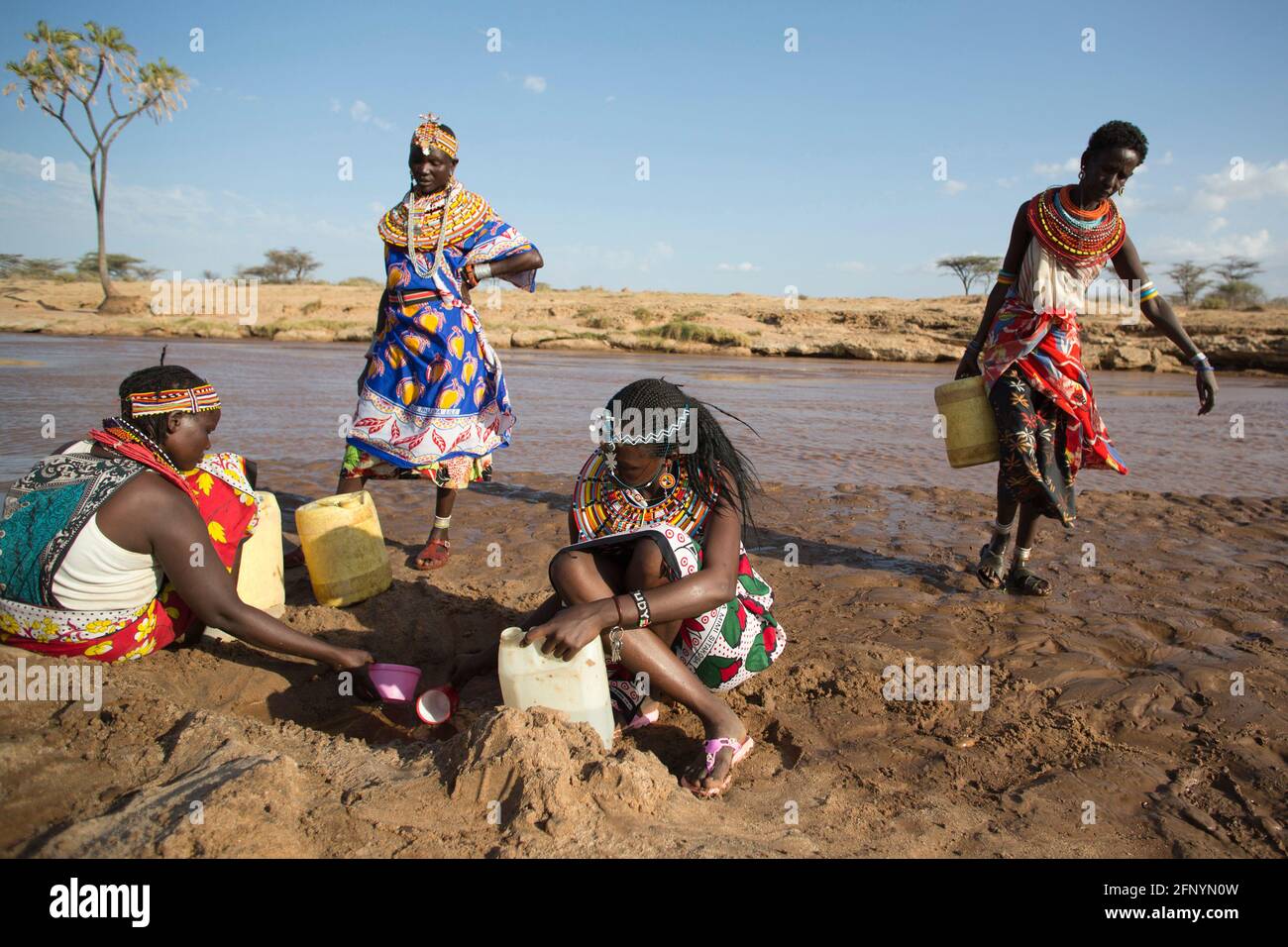 Women collect water from a river near the village of Umoja in Samburu, Kenya on February 19, 2015. Stock Photo