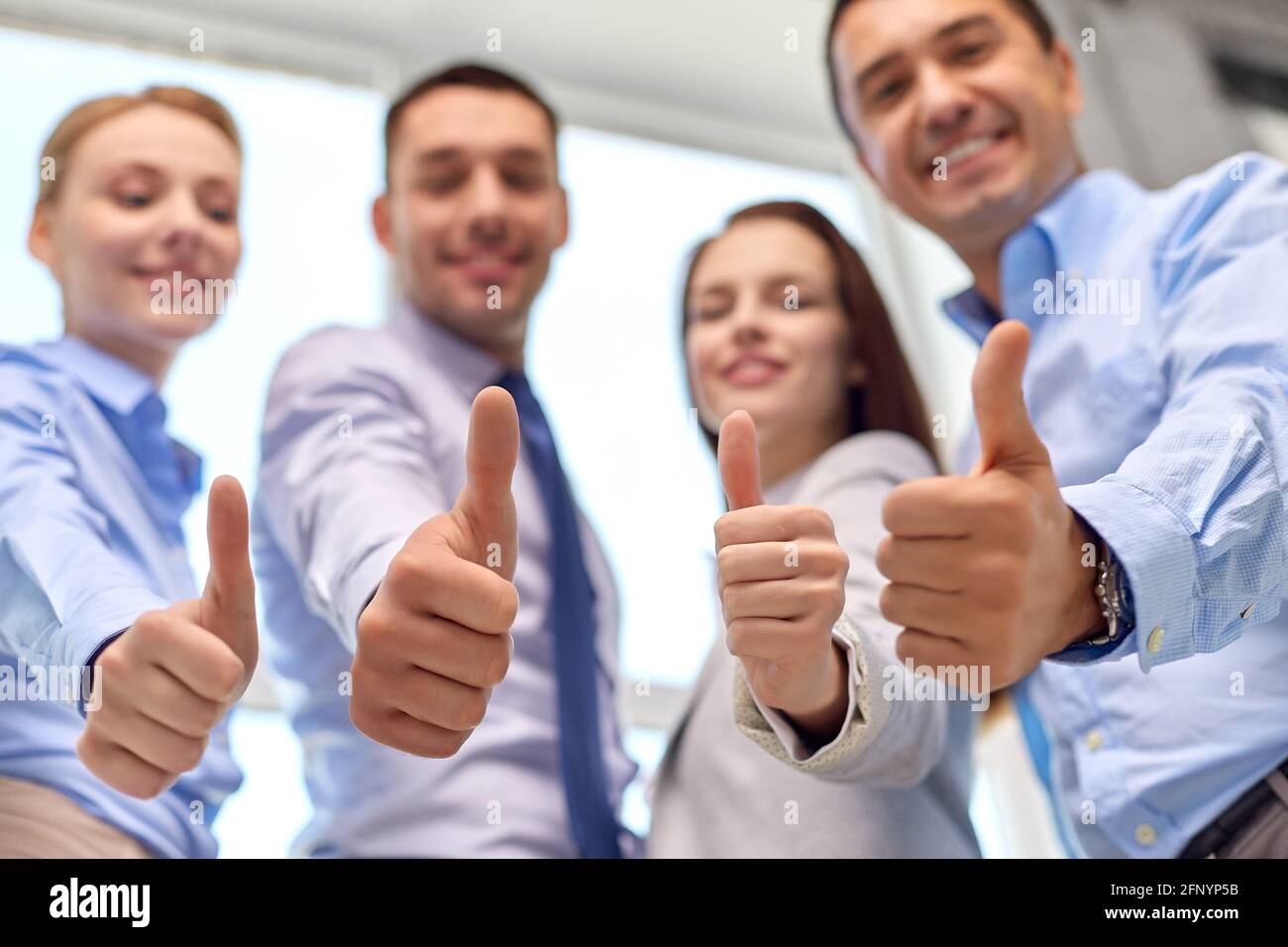 happy smiling business team showing thumbs up Stock Photo - Alamy