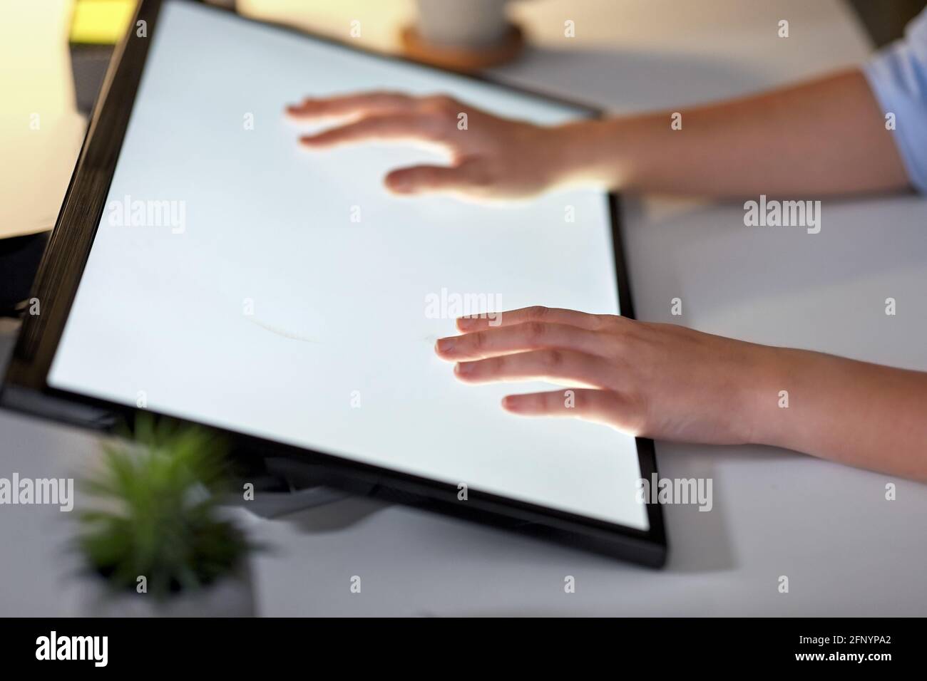 hands on led light tablet at night office Stock Photo