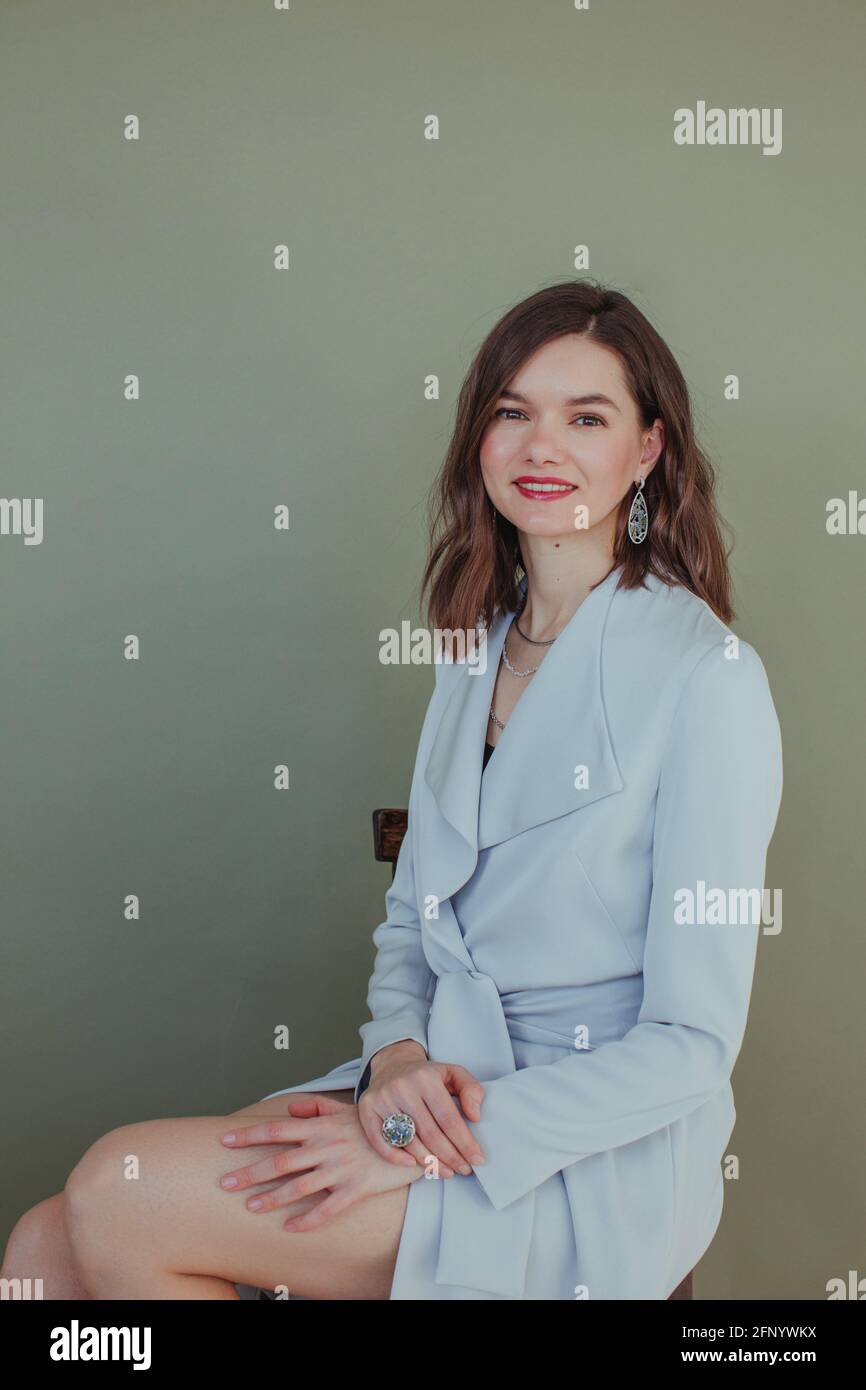 Portrait of a beautiful smiling woman sitting on a chair Stock Photo ...