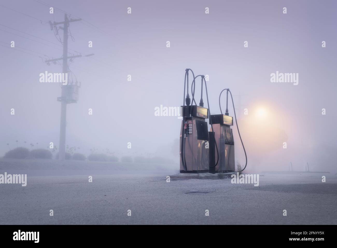 Old fashioned gas pumps on a foggy street at dawn, Australia Stock Photo