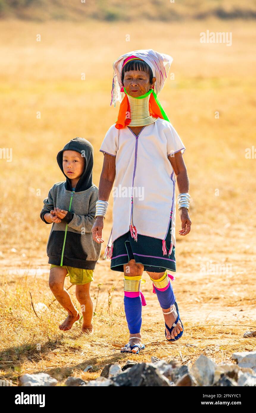 Rather jarringly, a grandmother poses in traditional grab next to her son wearing a modern day hoodie. MYANMAR: MEET THE women of the Kayan tribe who Stock Photo