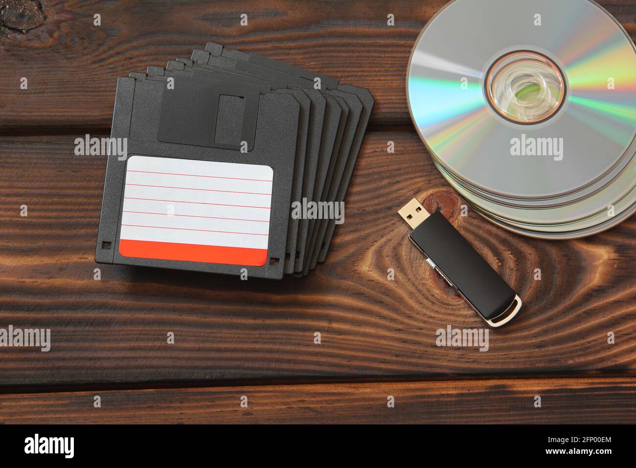Floppy disks, USB flash drive and disks on a wooden background Stock Photo
