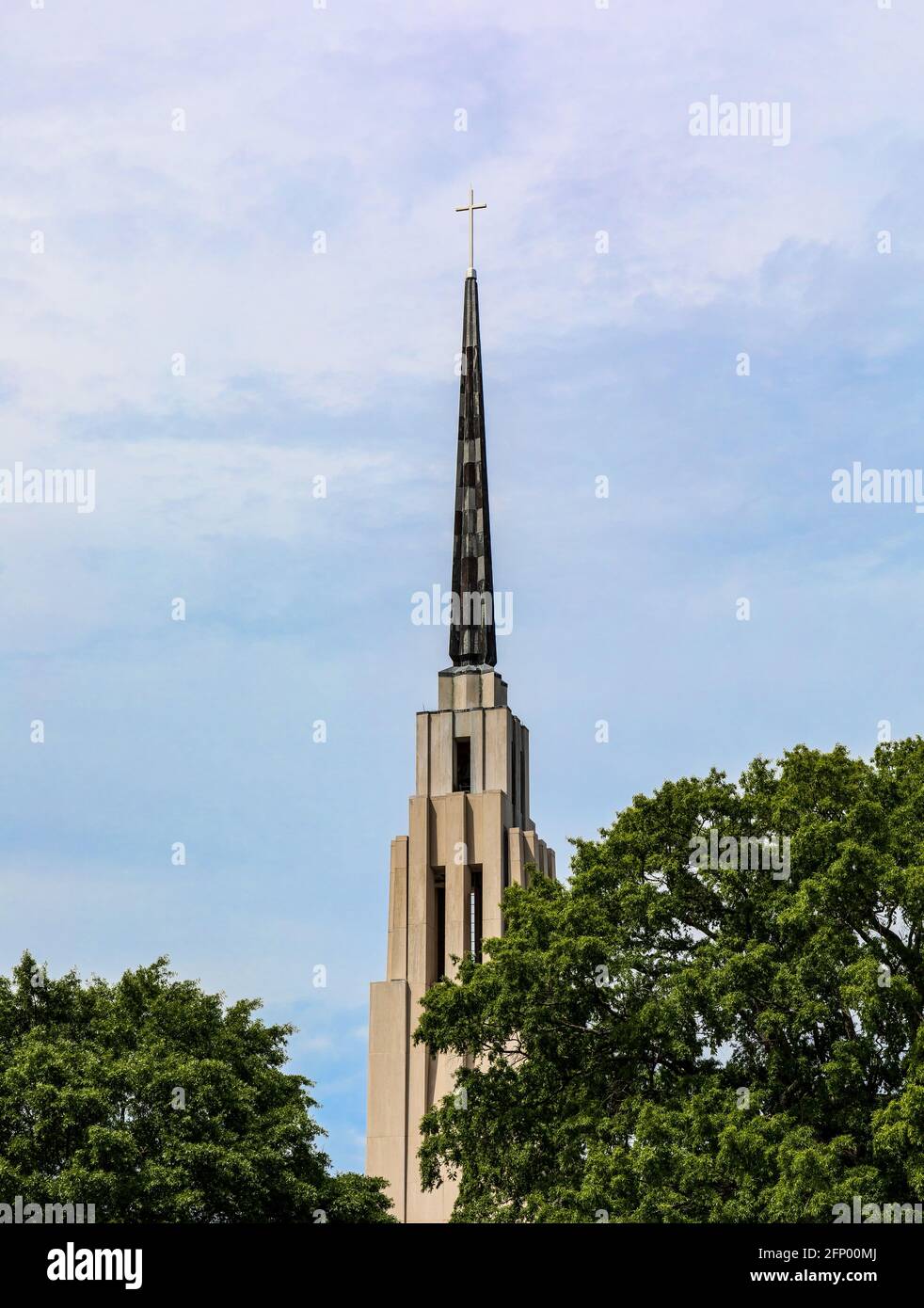 CHATTANOOGA, TN, USA-8 MAY 2021: The First-Centenary United Methodist Church bell tower and steeple.  Only the tower, green trees and blue sky in imag Stock Photo