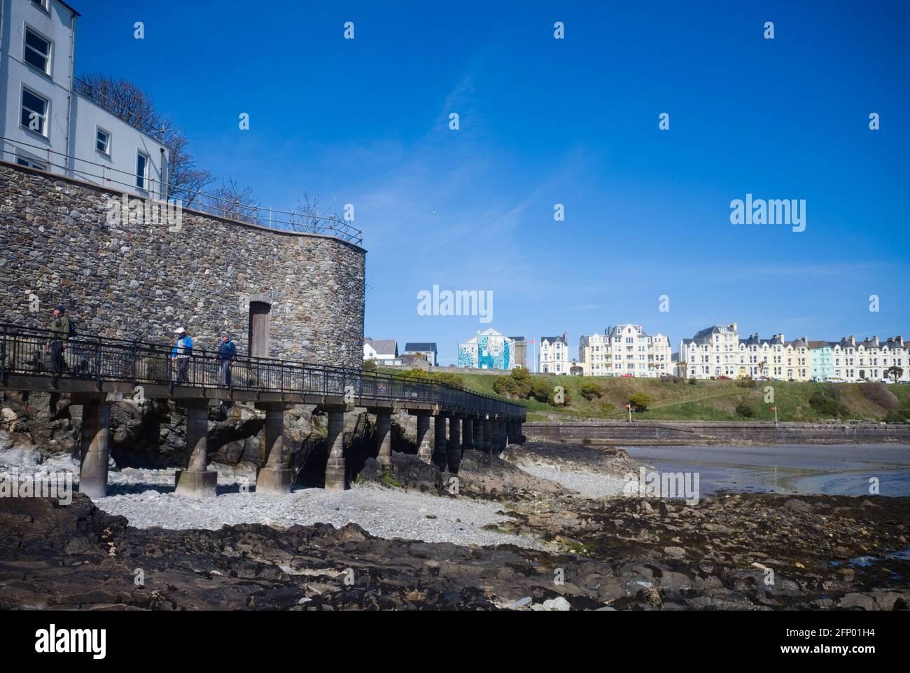The Cat Walk viewed from sea level at low tide, Port St Mary, Isle of Man with the beach and former guest houses on the promanade in the background Stock Photo