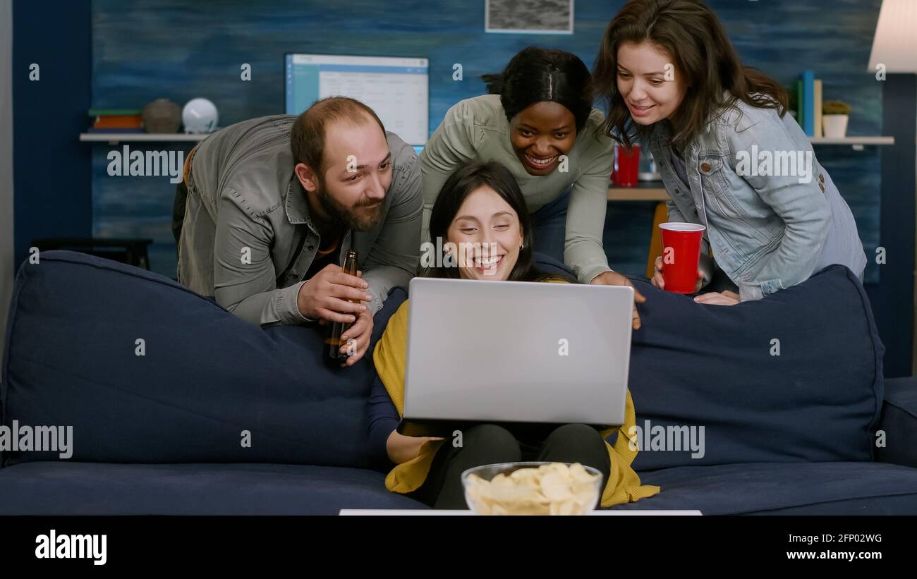 Friends Using Laptop On Sofa Mixed Race Typing Having Photo